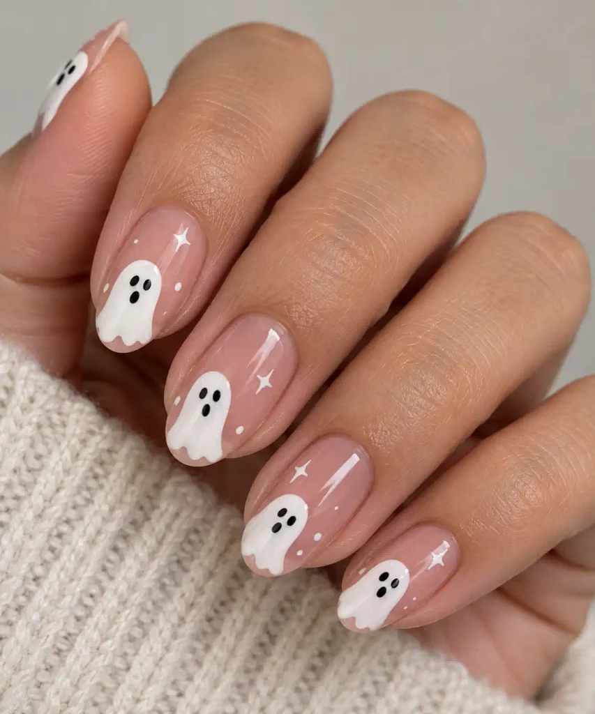 Cute white ghost face nail art design on a natural nail